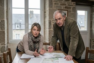 Femme et homme discutent sérieusement à table en Bretagne